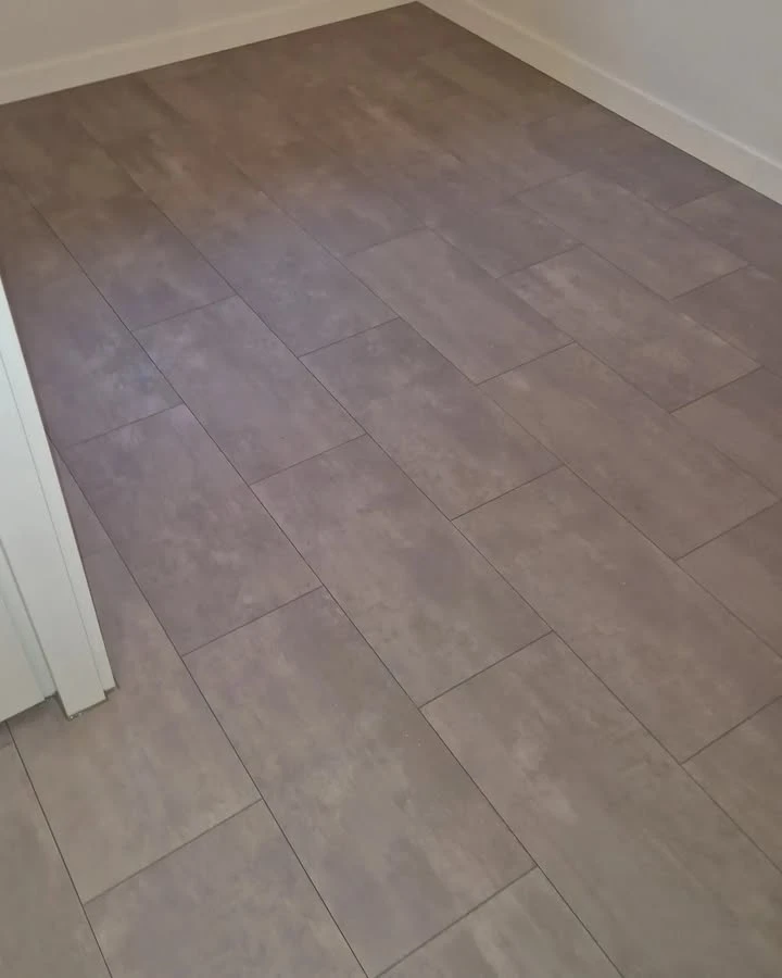 Hier hebben we een tegel laminaatvloer mogen leggen en plinten geplaatst.